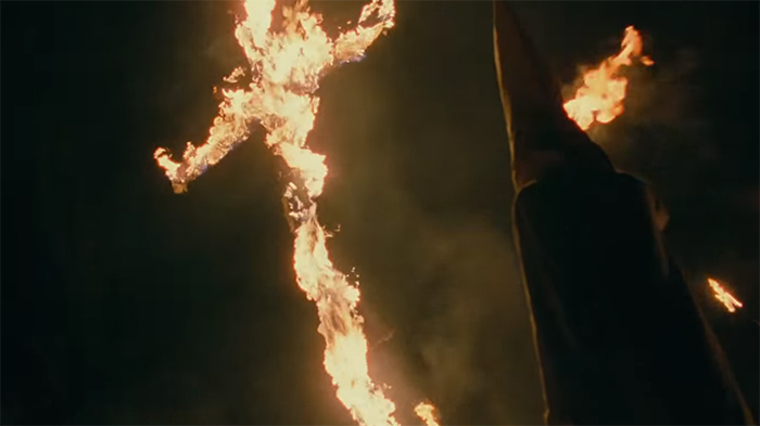 A cross burning, while the cowards hide behind their masks.