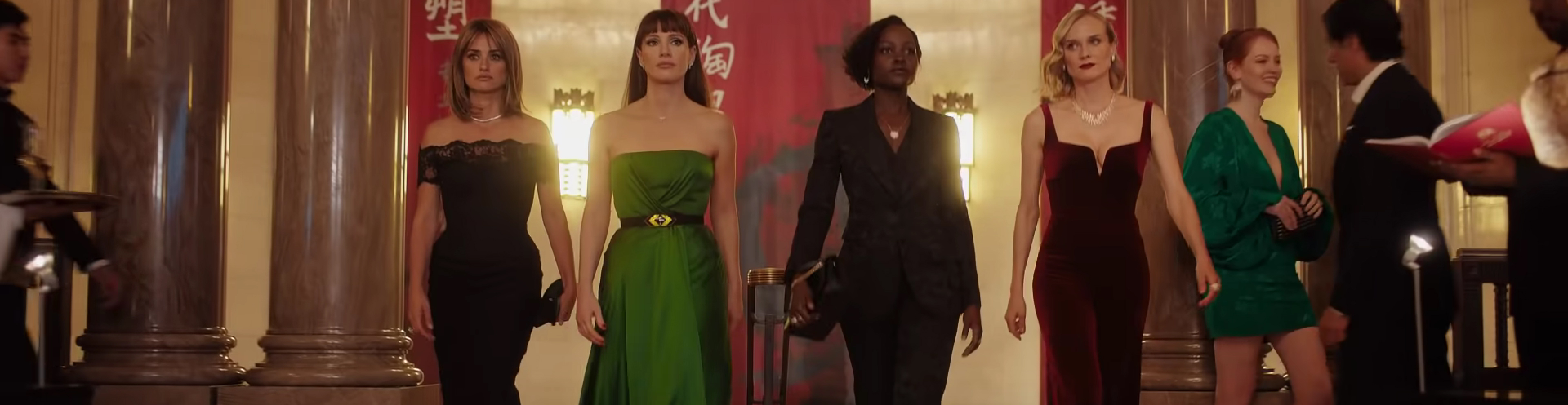 The cast walk into an auction in fancy dress.