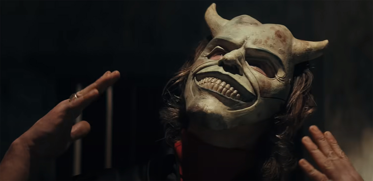 The Grabber shows off his mask.