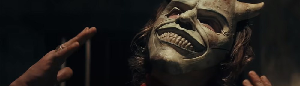 The Grabber shows off his mask.