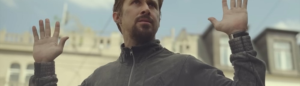 Ryan Gosling with his hands up.