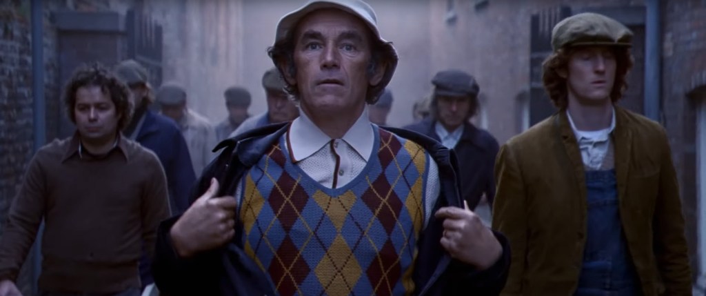 Maurice reveals his golf clothes under his work uniform like superman.