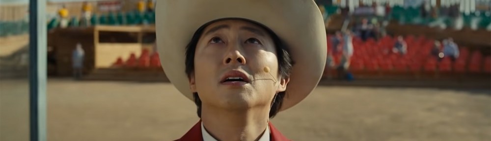 Steven Yeun looking up at the sky.