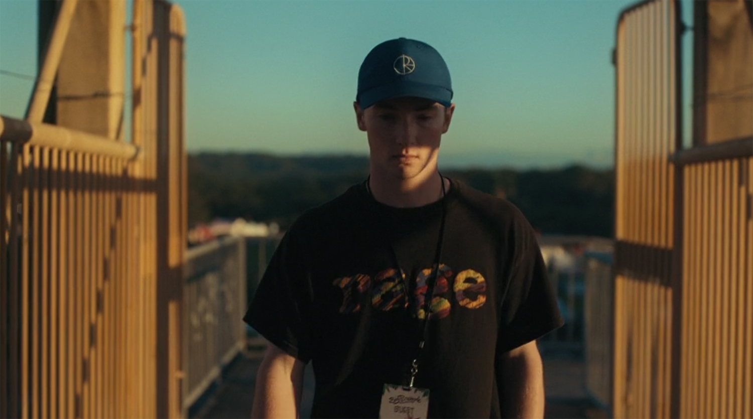 James walks along a bridge to the Big Pineapple.