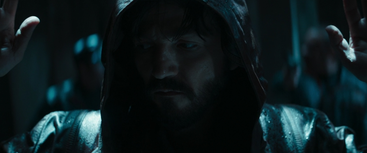 Andor has his hands up as he is acosted by Corpos.