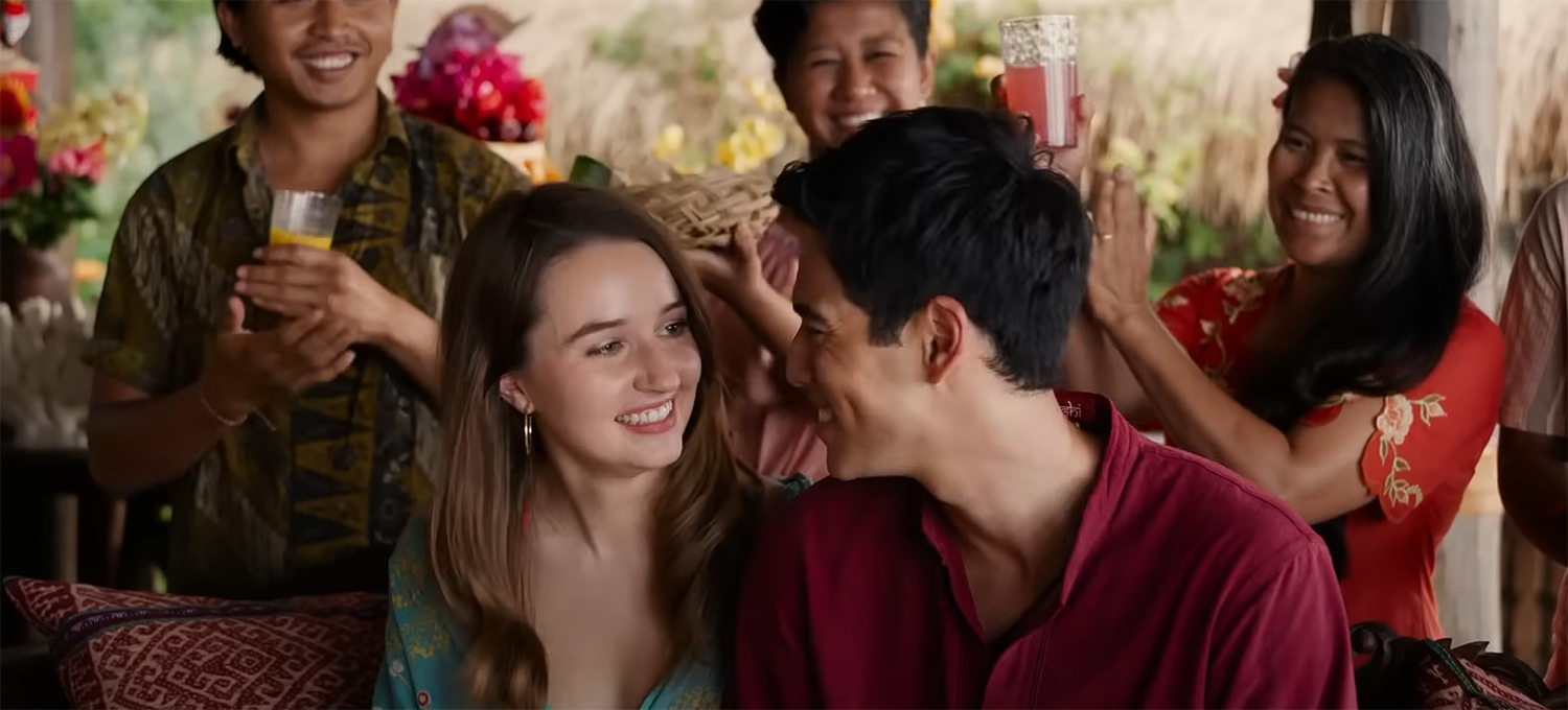 Kaitlyn Dever & Maxime Bouttier look at each other lovingly.