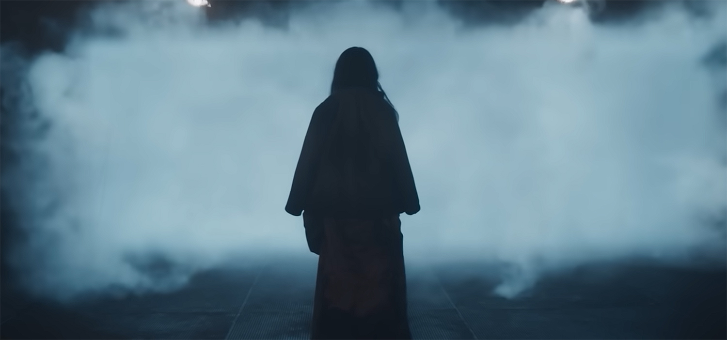 Ling Yi (Isabella Wei) stands in front of a mysterious fog.