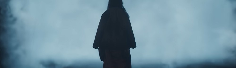 Ling Yi (Isabella Wei) stands in front of a mysterious fog.