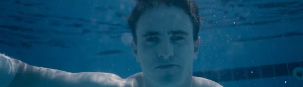 Calum under the water in a pool.