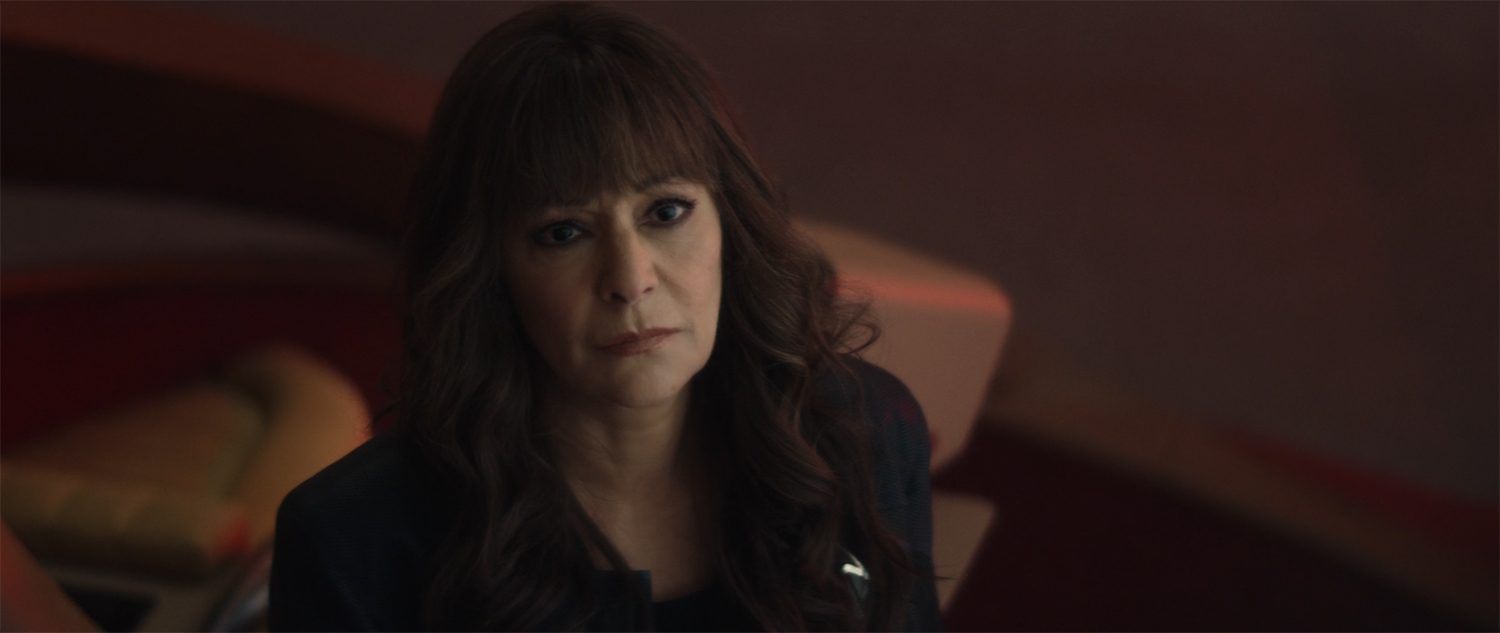 Deanna looks at Riker and they have a wordless conversation.