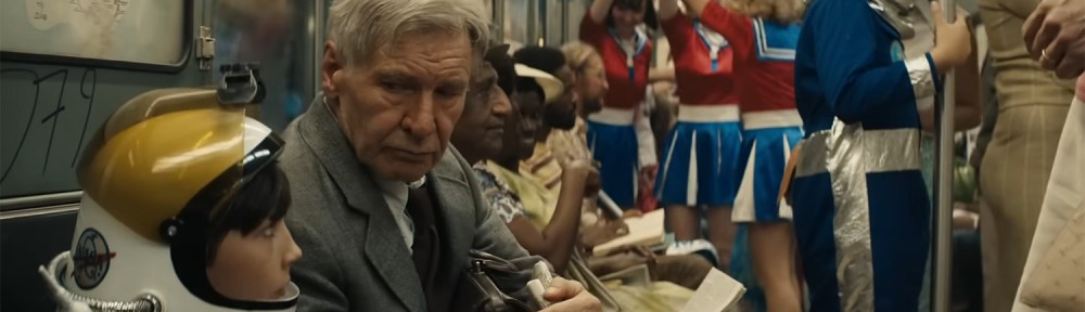 Indy on a train as everyone is dressed up in space outfits.