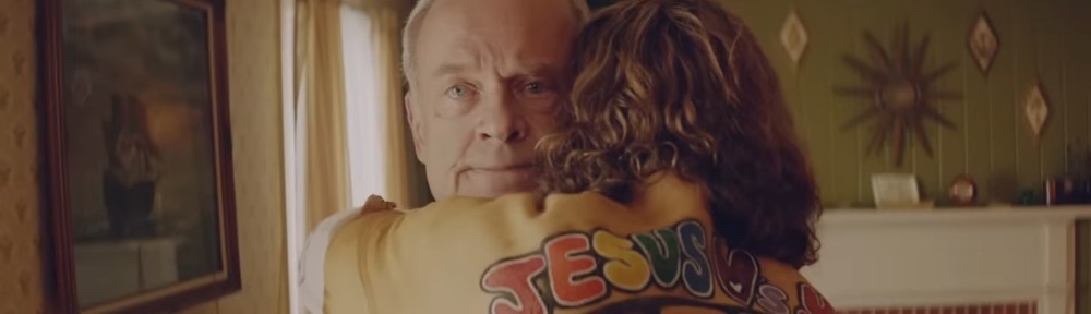 Chuck Smith gets surprise hugged by a hippie.