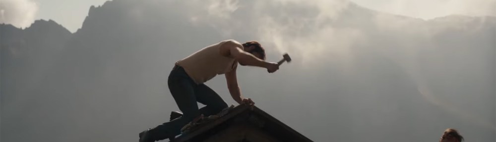 Two men fix a roof.