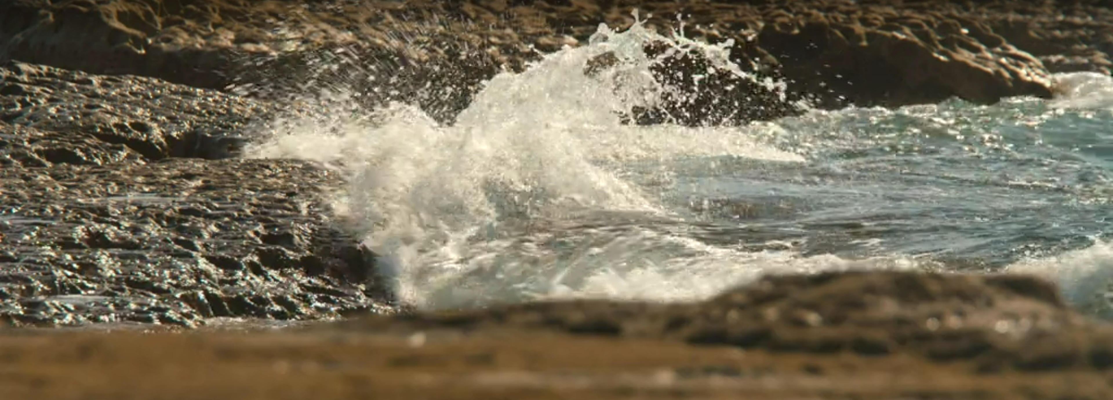 Waves crashing into the rocks.