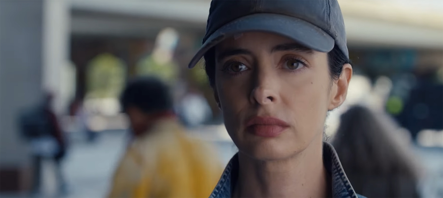 Krysten Ritter hiding with a baseball cap.