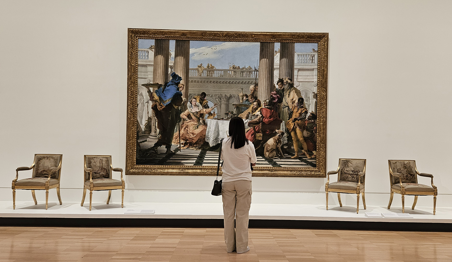 A woman stands observing a work of art.