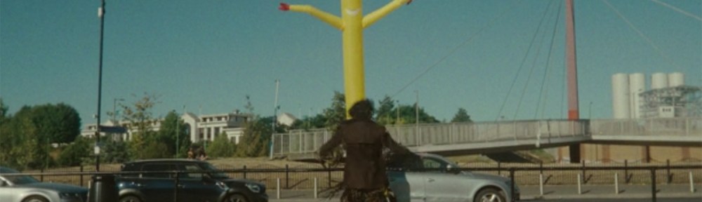 Loki timeslips in front of a flailing wacky inflatable man.