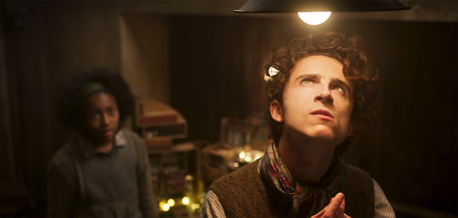 Timothée Chalamet standing under a light getting an idea