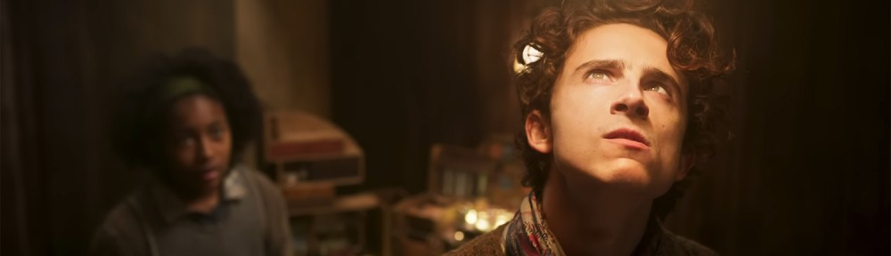 Timothée Chalamet standing under a light getting an idea