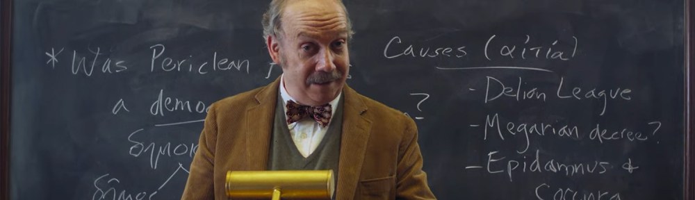 Paul teaching Greek History behind a blackboard.