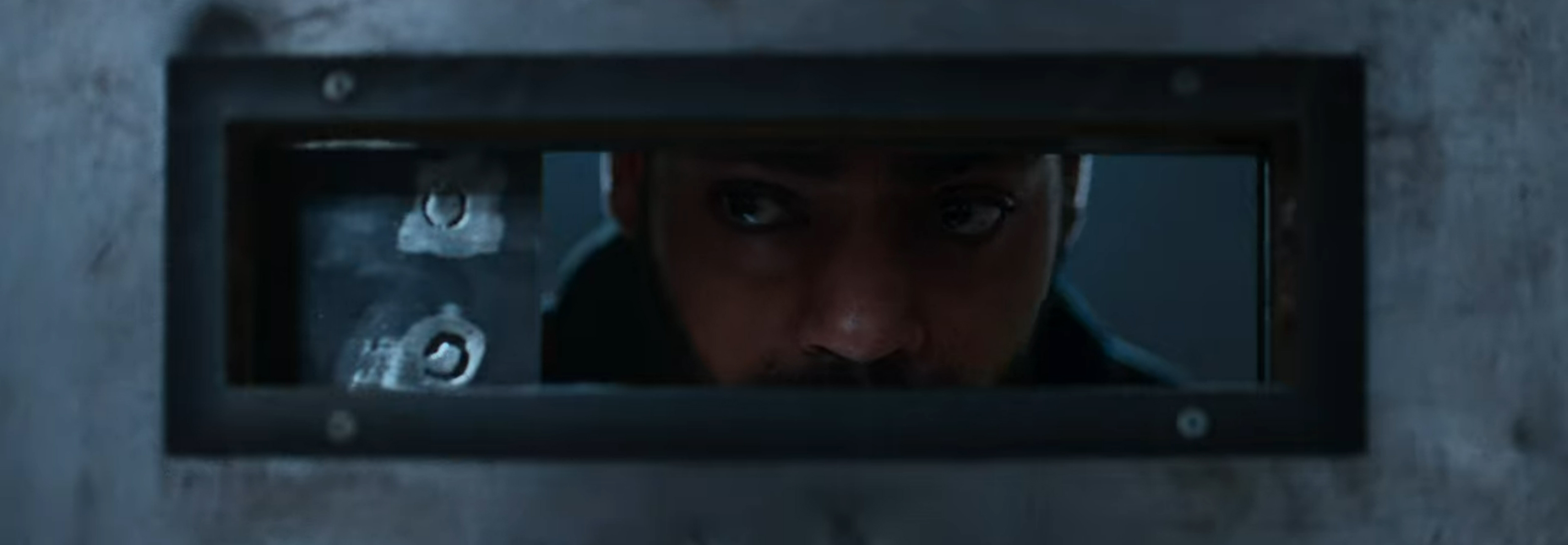 Izi pears out from behind the slit in his door.