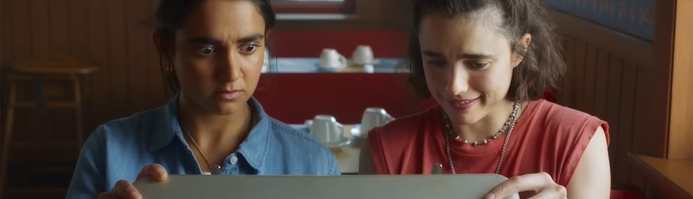 Margaret Qualley & Geraldine Viswanathan look in the briefcase.