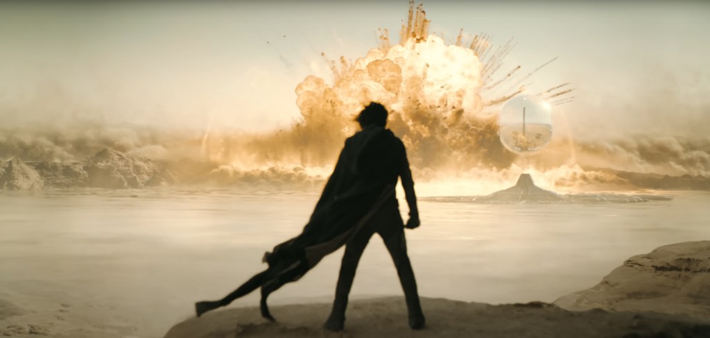 Paul stands in front of an explosion.