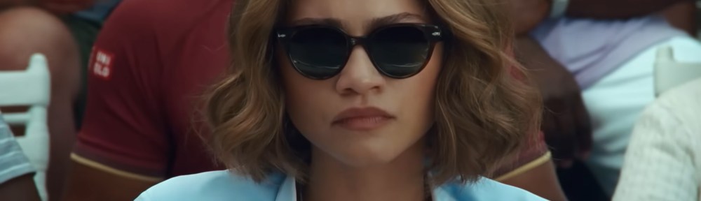 Tashi Duncan (Zendaya) watches the tennis match behind sunglasses.