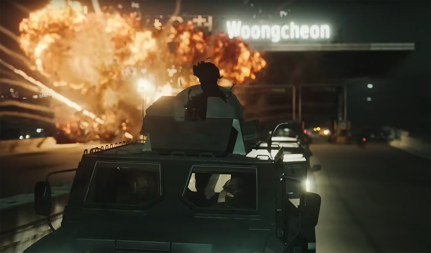 An explosion behind an army truck.