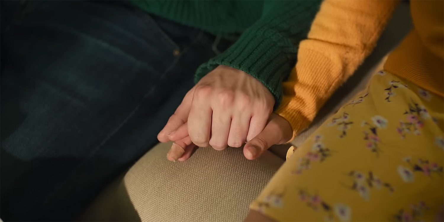 Aza and Davis hold hands.