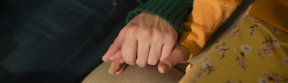 Aza and Davis hold hands.