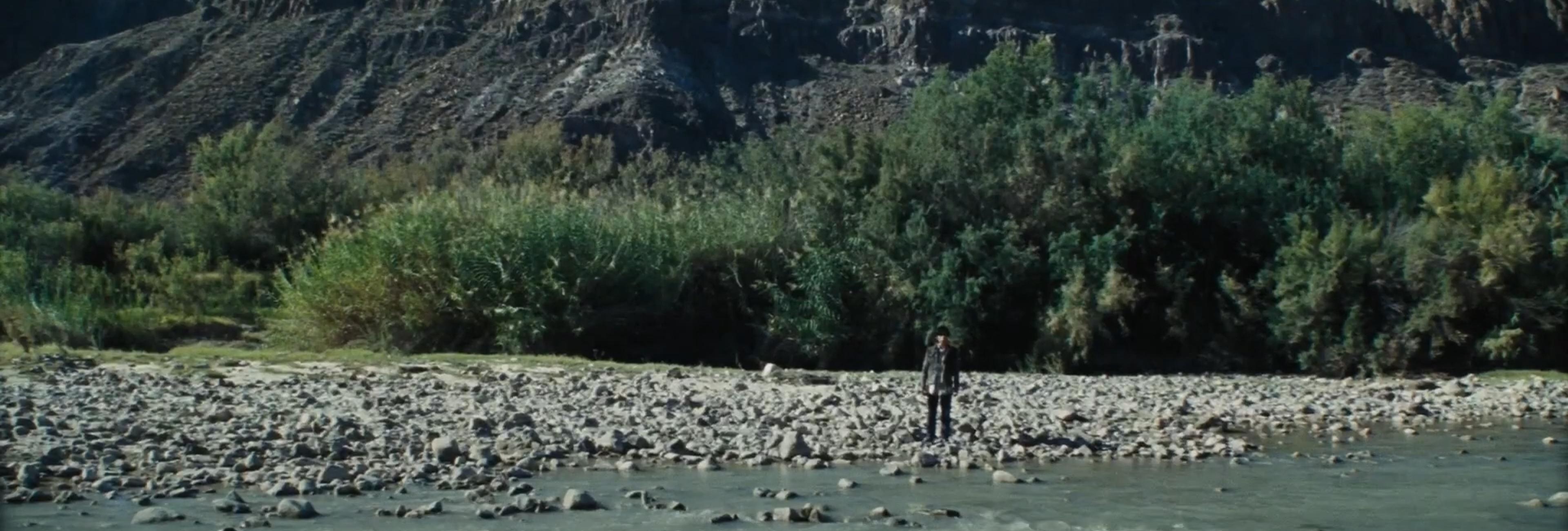 A man standing on the river's shore.