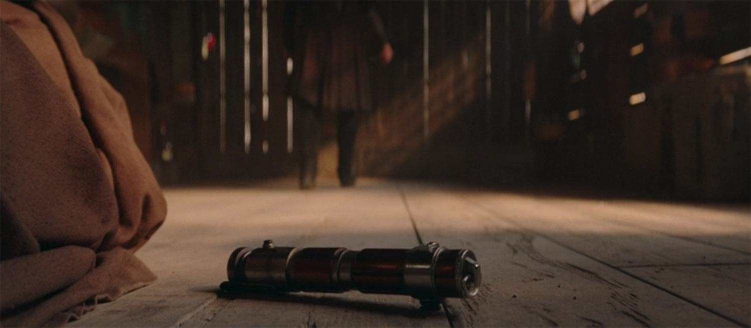 The lightsabre of a dead Jedi falls to the ground.
