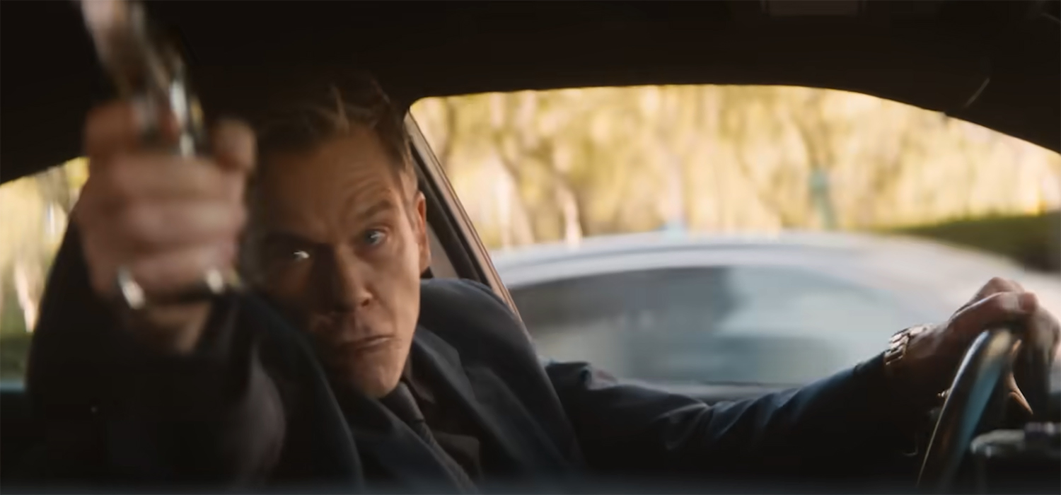 Kevin Bacon shooting a gun.