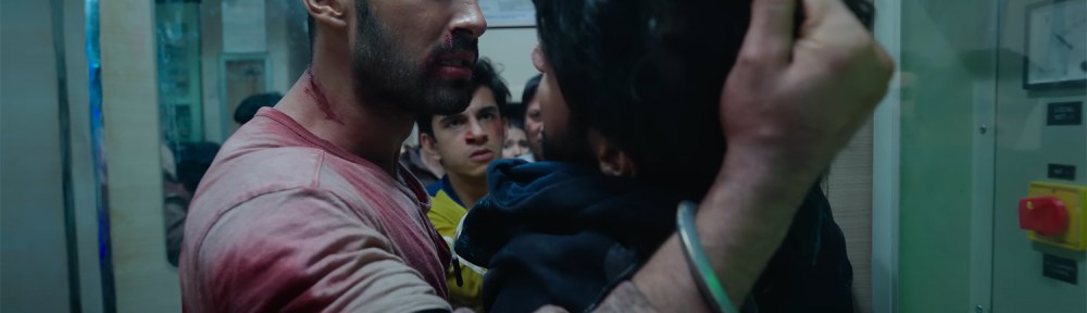 Amrit holds a bandit by his hair.