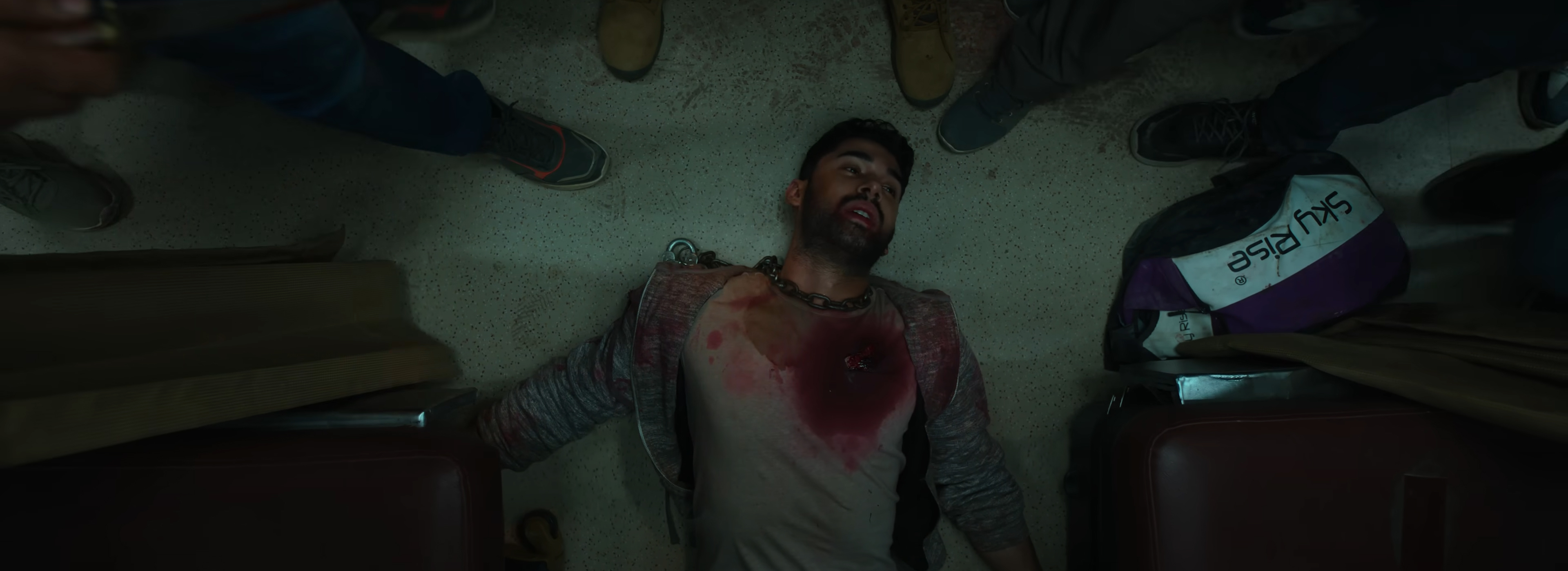 Amrit, bloodied on the floor surrounded by bandits.