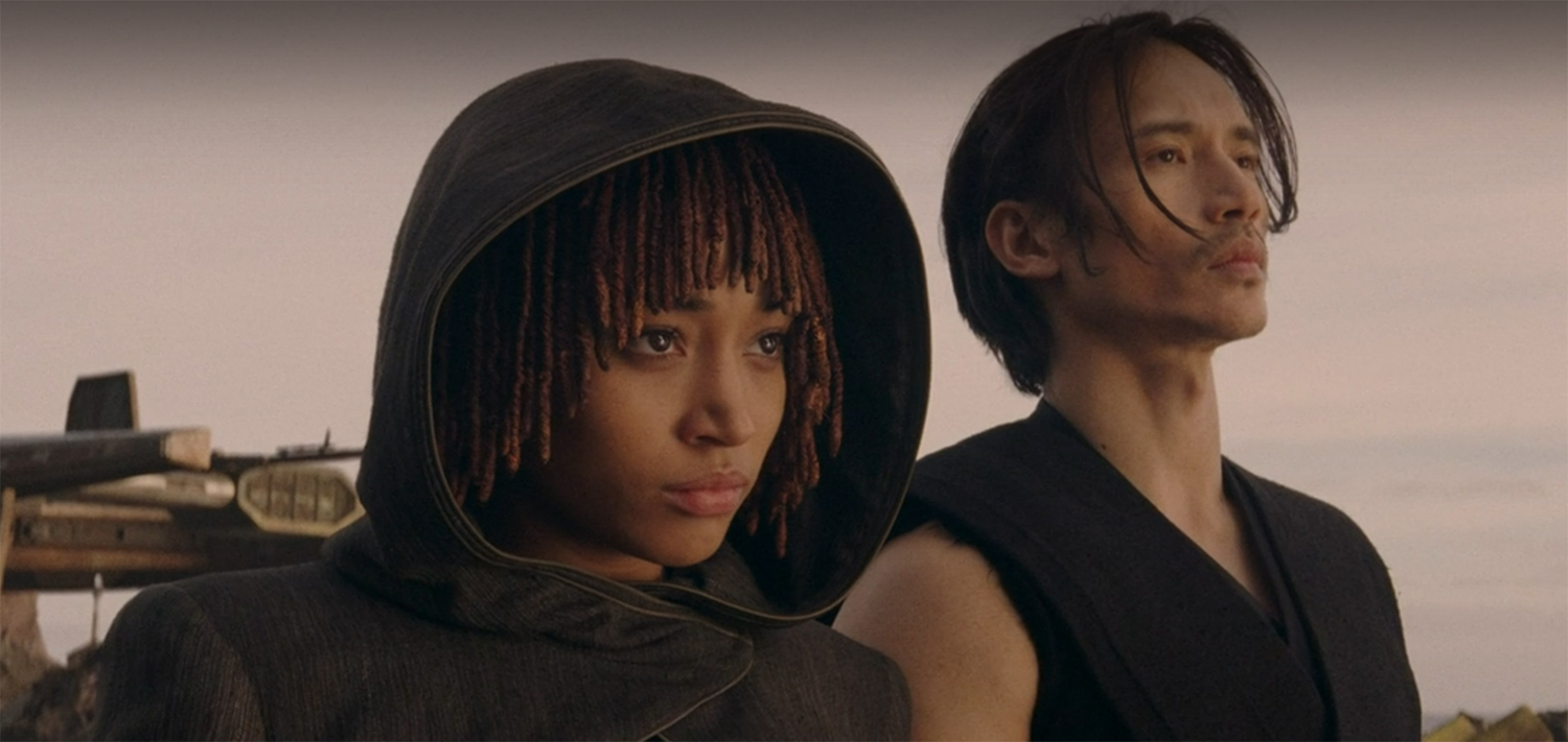 Qimir and Osha stand on an unknown planet, but looking towards camera this time.