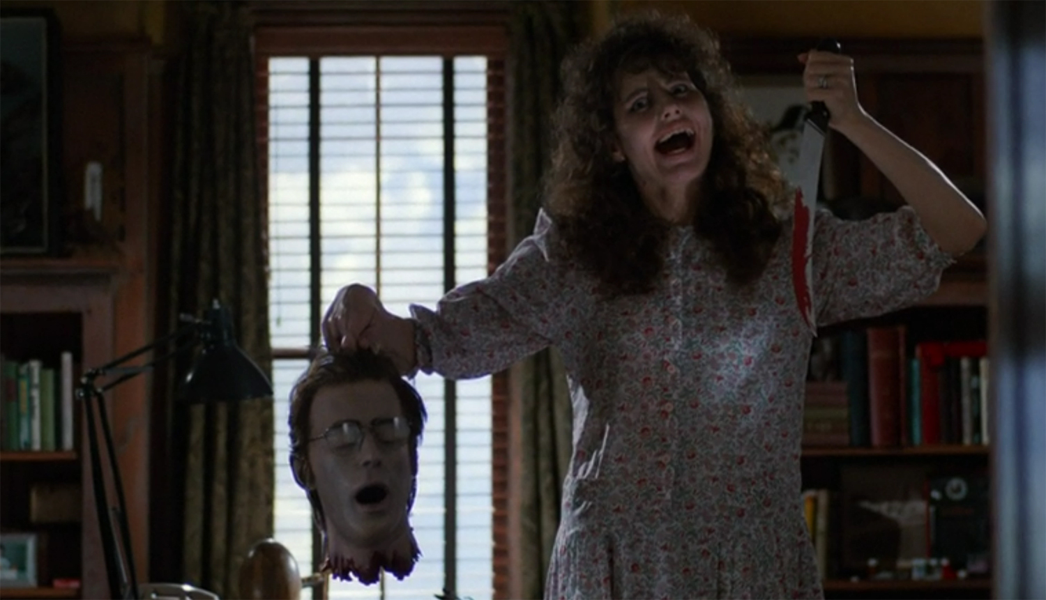 Barbara Maitland holds a knife and the severed head of her ghost husband Adam.