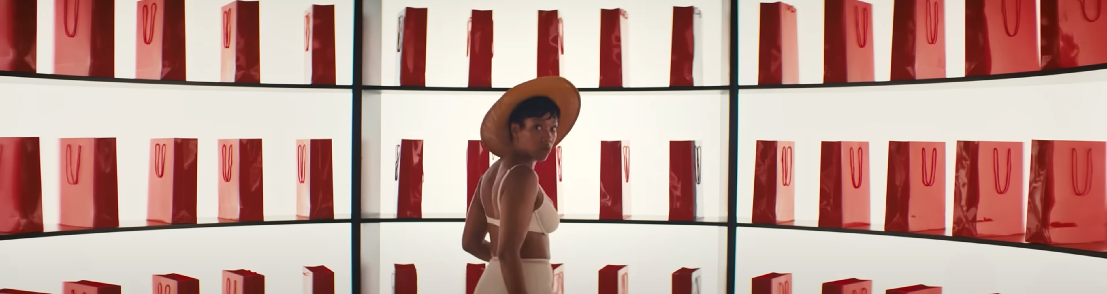 Frida stands in front of a bunch of red bags all lined up.