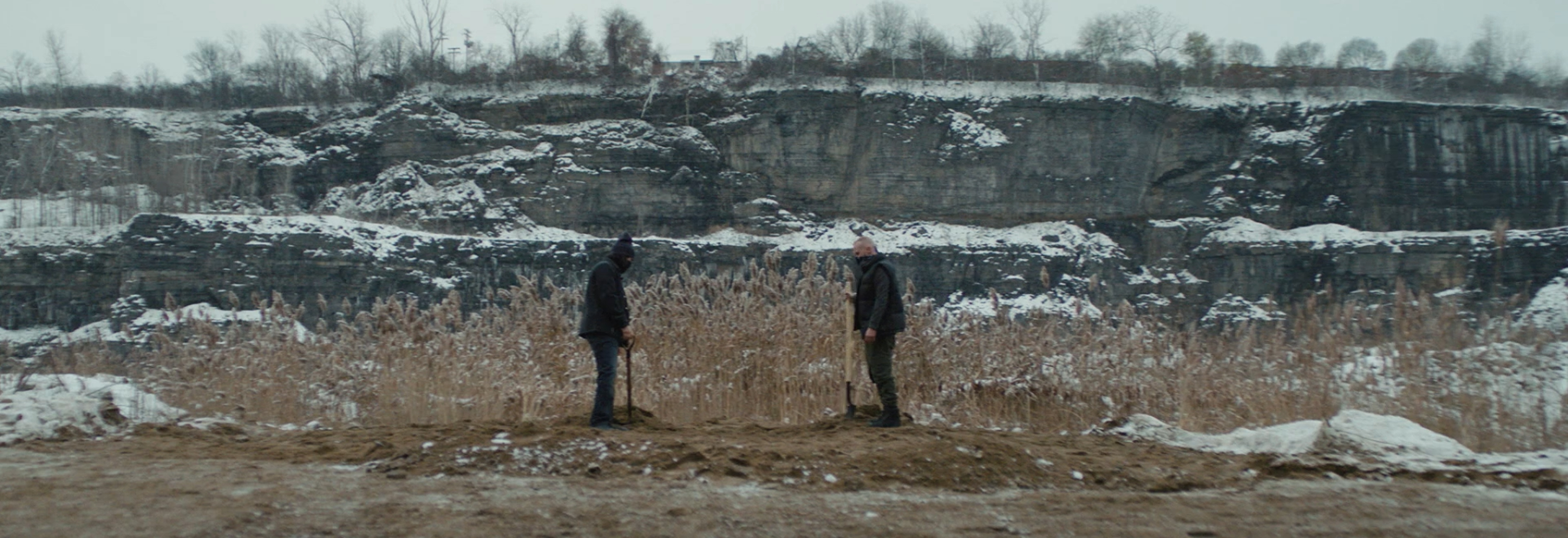 Two men burring a person.