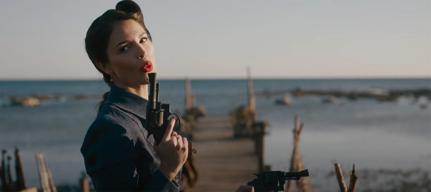 Marjorie Stewart blows smoke of the top of a gun.