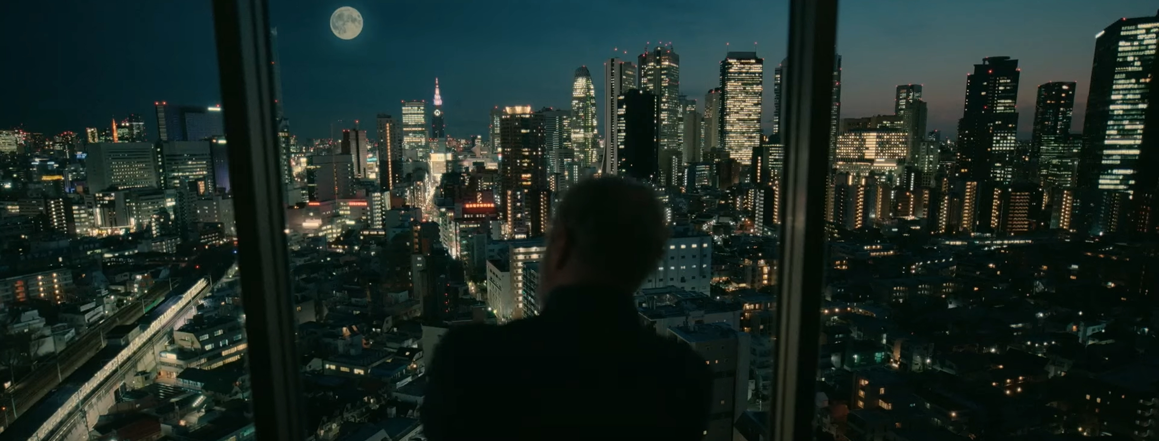 Kristófer looks out over a city scape.