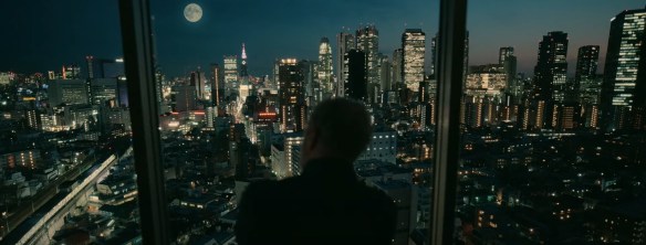 Kristófer looks out over a city scape.