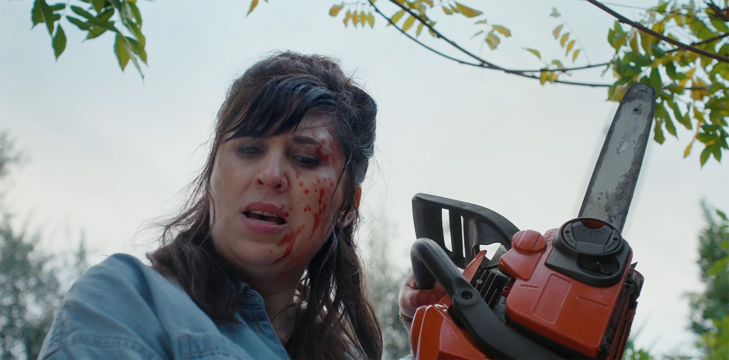 Abi holds a chainsaw.