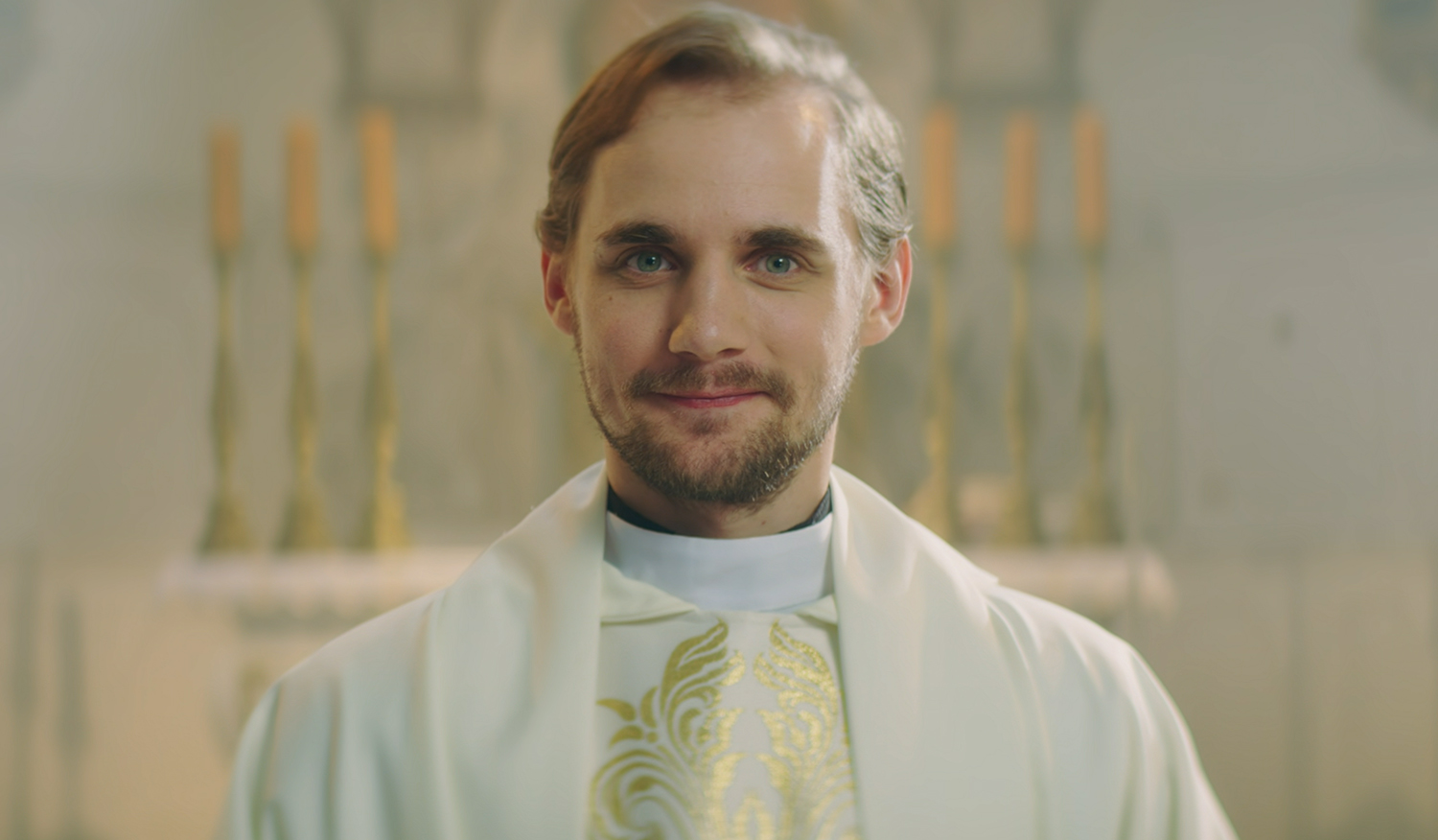 Priest Tomek smiles.