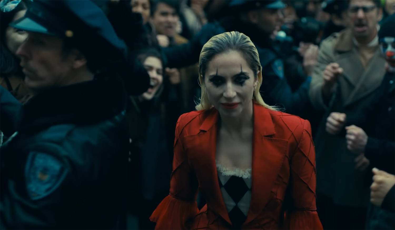 Harleen “Lee” Quinzel walks up the steps of court in full clown outfit.