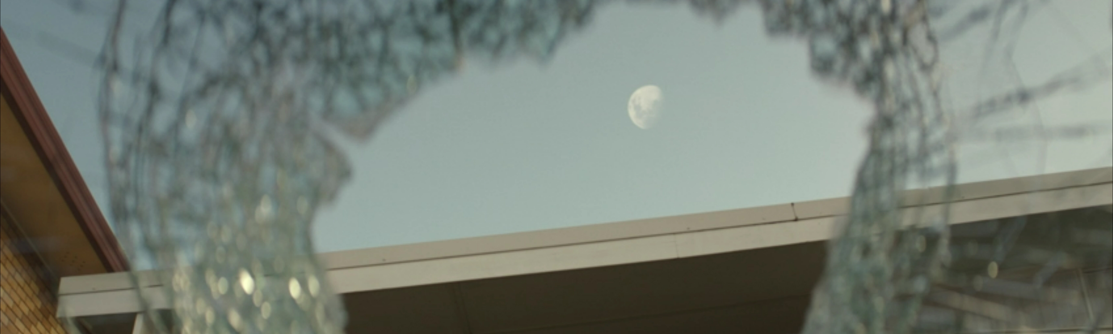 The Moon rising through a smashed windscreen.