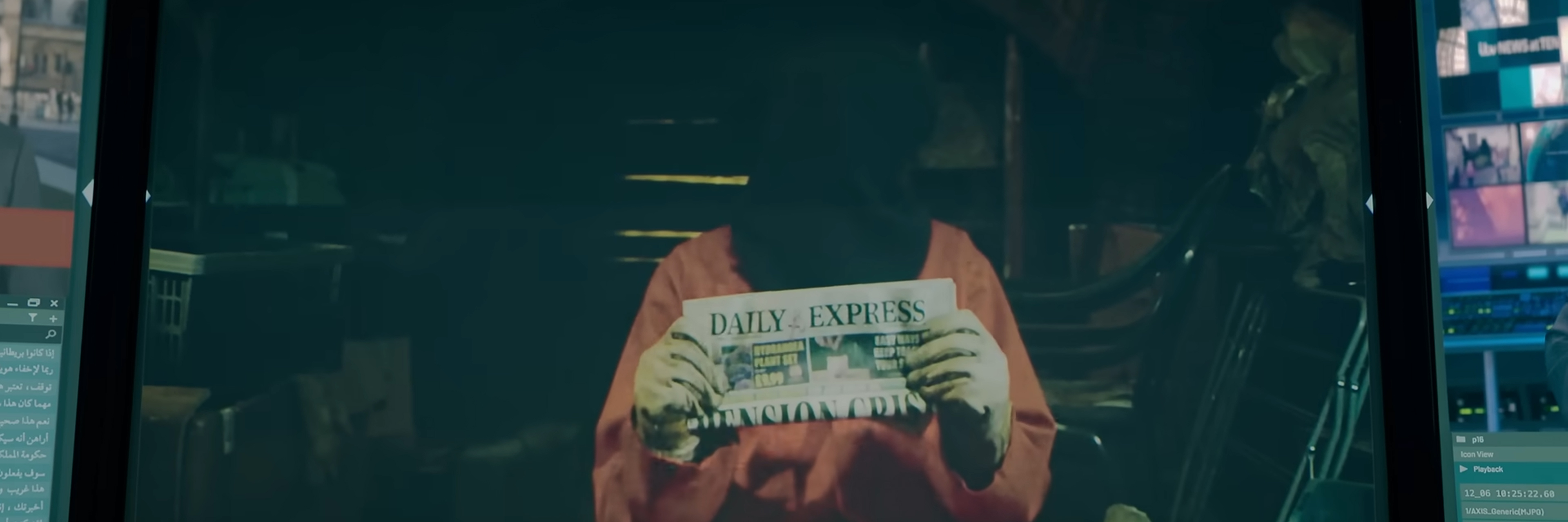 Hodded man holding up the day's newspaper.