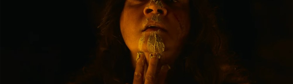 Sarah paints ochre down her face.