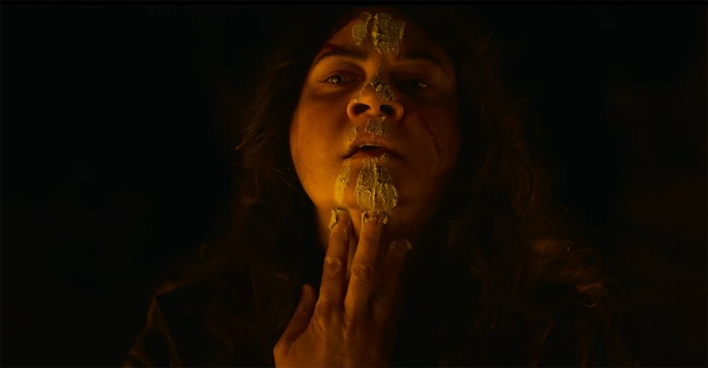 Sarah paints ochre down her face.